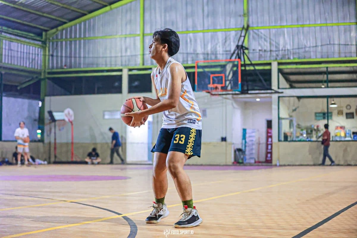 Dhanes about to shoot a basketball in an indoor court